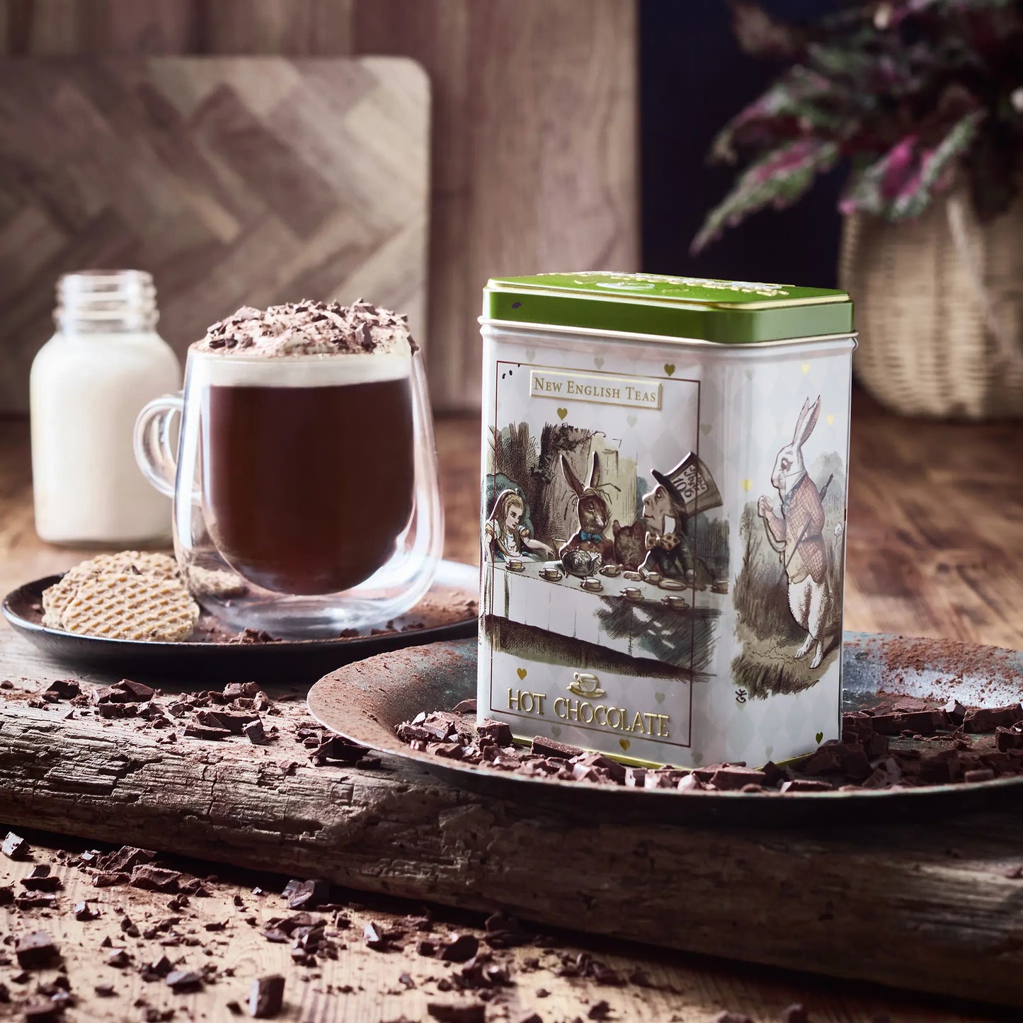 Hot chocolate with a vintage-style Alice In Wonderland canister on a wooden surface with chocolate shavings