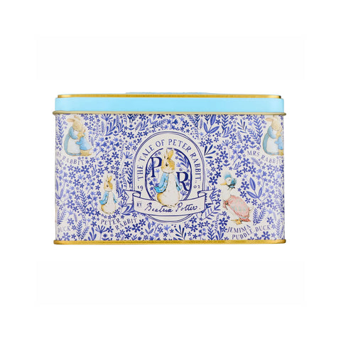 A rectangular metal tin with a light blue lid and gold trim, decorated with a blue floral pattern and illustrations from Peter Rabbit, including Beatrix, Peter Rabbit, and the title 'The Time of Peter Rabbit'.
