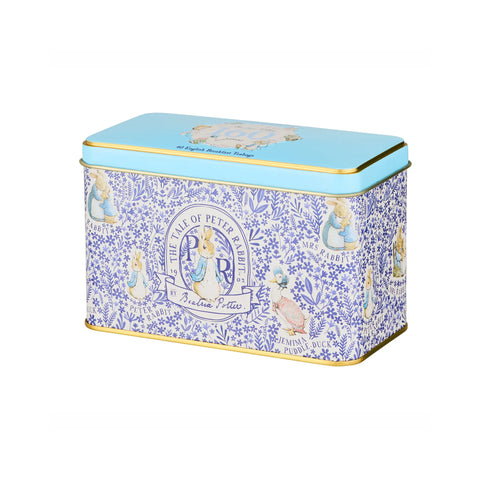 A rectangular metal tin with a light blue lid and gold trim, decorated with a blue floral pattern and Peter Pan illustrations on the sides, photographed on a plain white background.