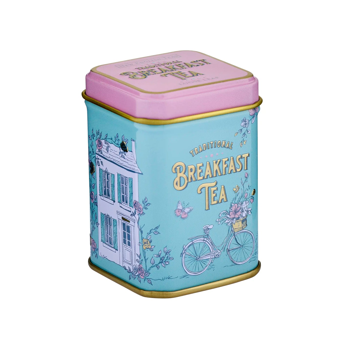 A square metal tea tin with a pastel blue body, pink lid, and gold trim, decorated with illustrations of a house, bicycle, and flowers, and the words 'Traditional Breakfast Tea' on the lid.