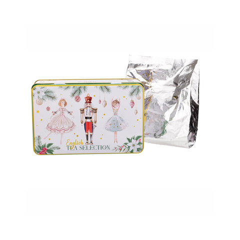 A decorative rectangular tin labeled 'English Tea Selection' with illustrated characters and holiday motifs, shown in front of a silver foil tea bag pouch on a white background.
