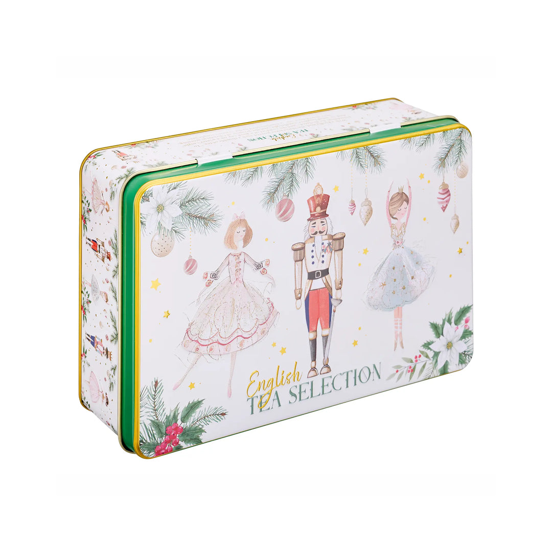 A rectangular metal tea tin with a white background decorated with Christmas illustrations, including a nutcracker, ballerinas, pine branches, ornaments, and the text 'English TEA SELECTION'.