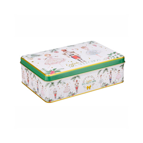 A rectangular metal tea tin with a white lid decorated with Christmas nutcracker illustrations and gold lettering, featuring a green band and gold trim, on a plain white background.