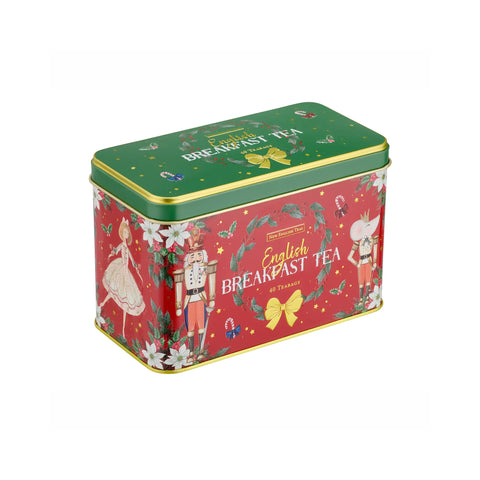 A rectangular metal tea tin with a festive Christmas design, featuring a red body with nutcracker illustrations, white flowers, and a green lid, labeled 'English Breakfast Tea'