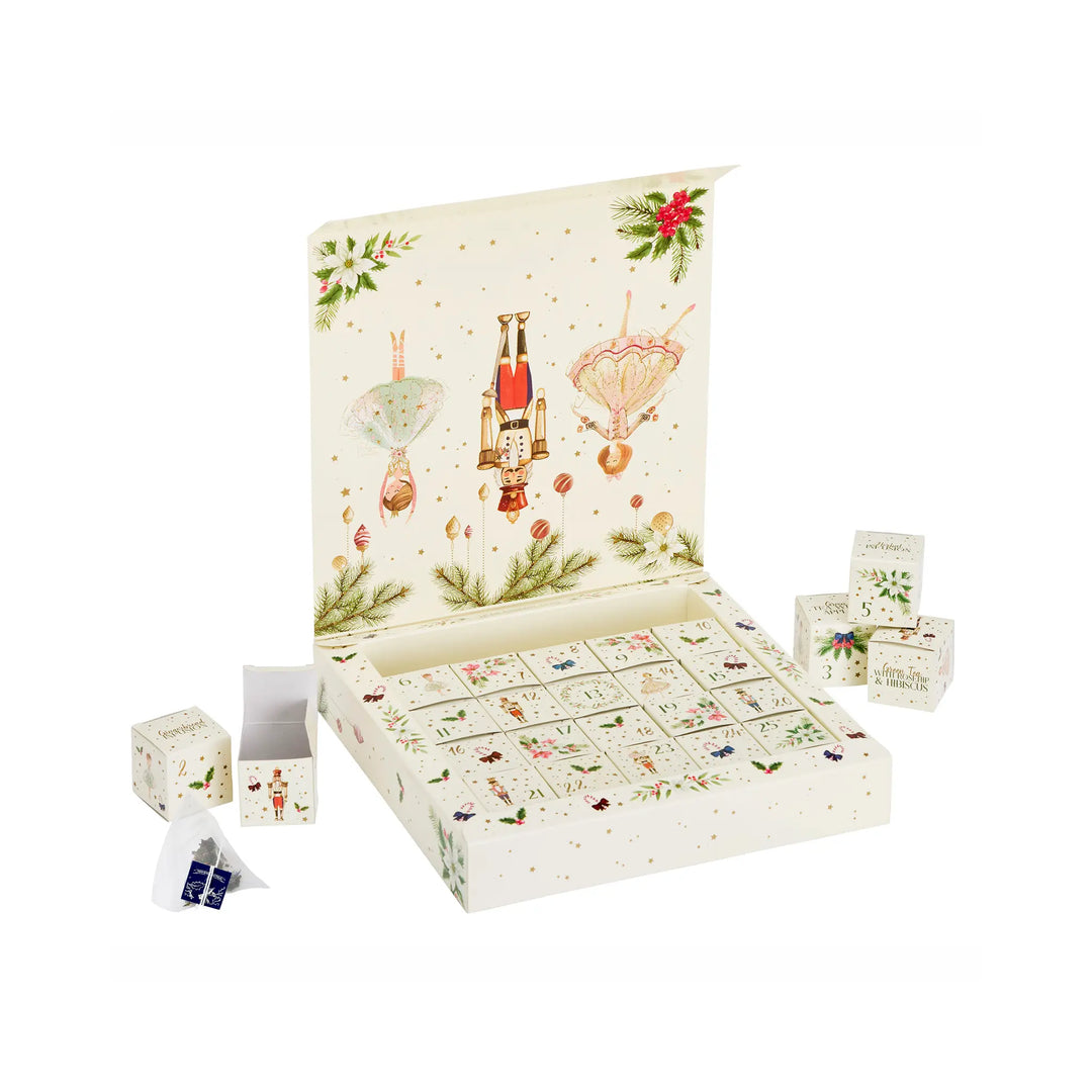 An open Christmas advent calendar box with multiple small gift boxes and a few wrapped items placed around it on a clean white background. The main box has a cream base with festive illustrations including a nutcracker, ornaments, holly, and gold confetti.