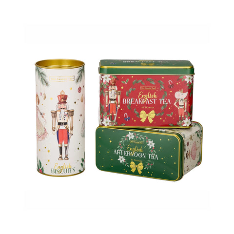 Three decorative metal tea and biscuit tins on a plain white background: a tall white tin with a nutcracker illustration and gold rim, a red square tin labeled English Breakfast Tea, and a green square tin labeled English Afternoon Tea stacked in front.