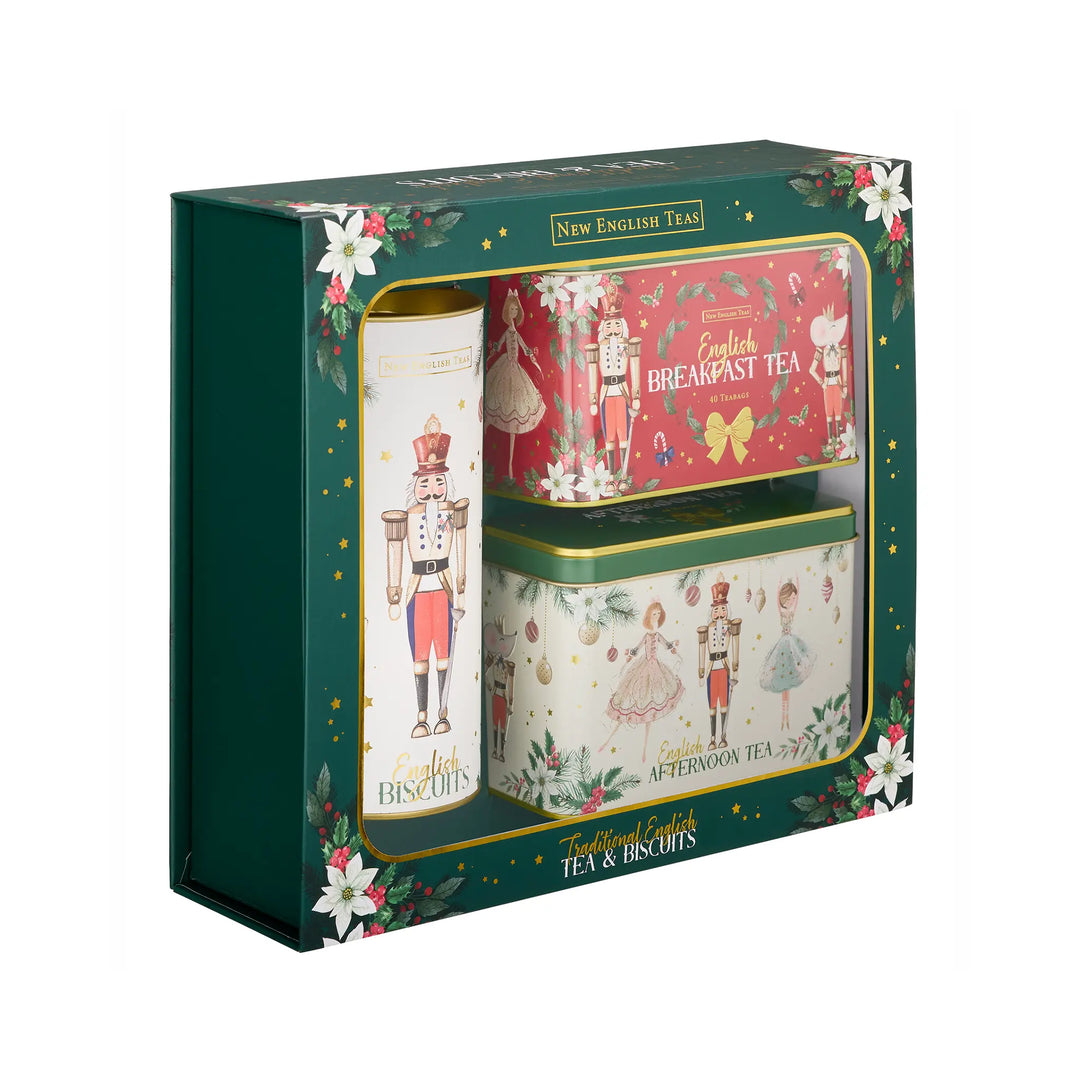 A boxed tea and biscuits gift set from New English Teas. The dark green gift box features festive floral illustrations and a clear window displaying a white biscuit tin with a nutcracker design, a red breakfast tea tin, and an afternoon tea tin with illustrated characters.