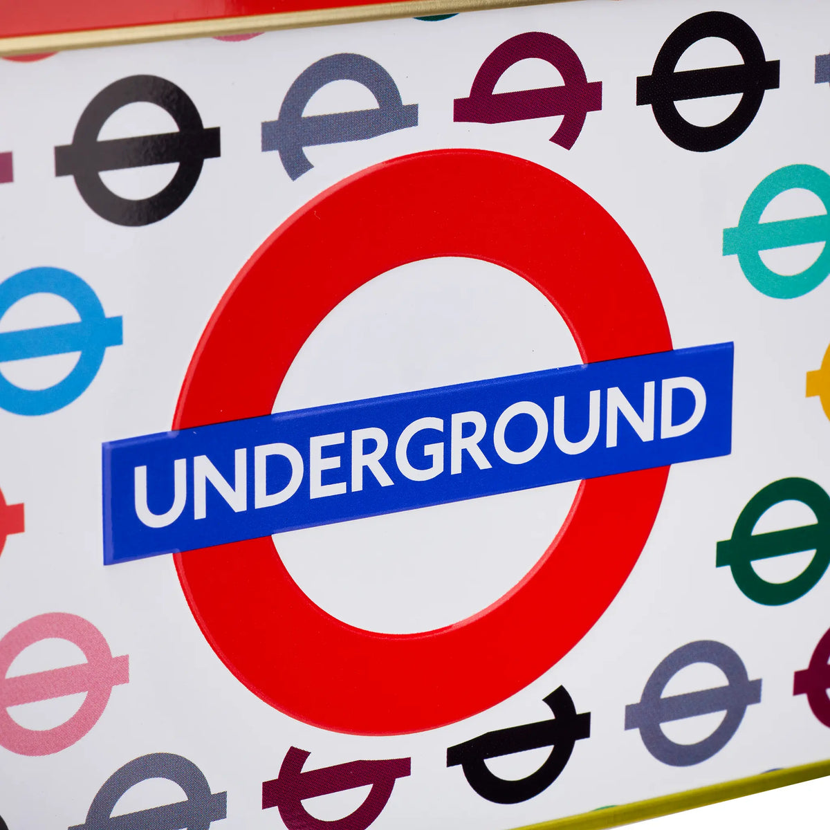 A close-up of a London Underground roundel sticker or decal on a white background with multiple colorful Underground station logo symbols around it. The central red circle with a blue banner reading UNDERGROUND is clearly visible.