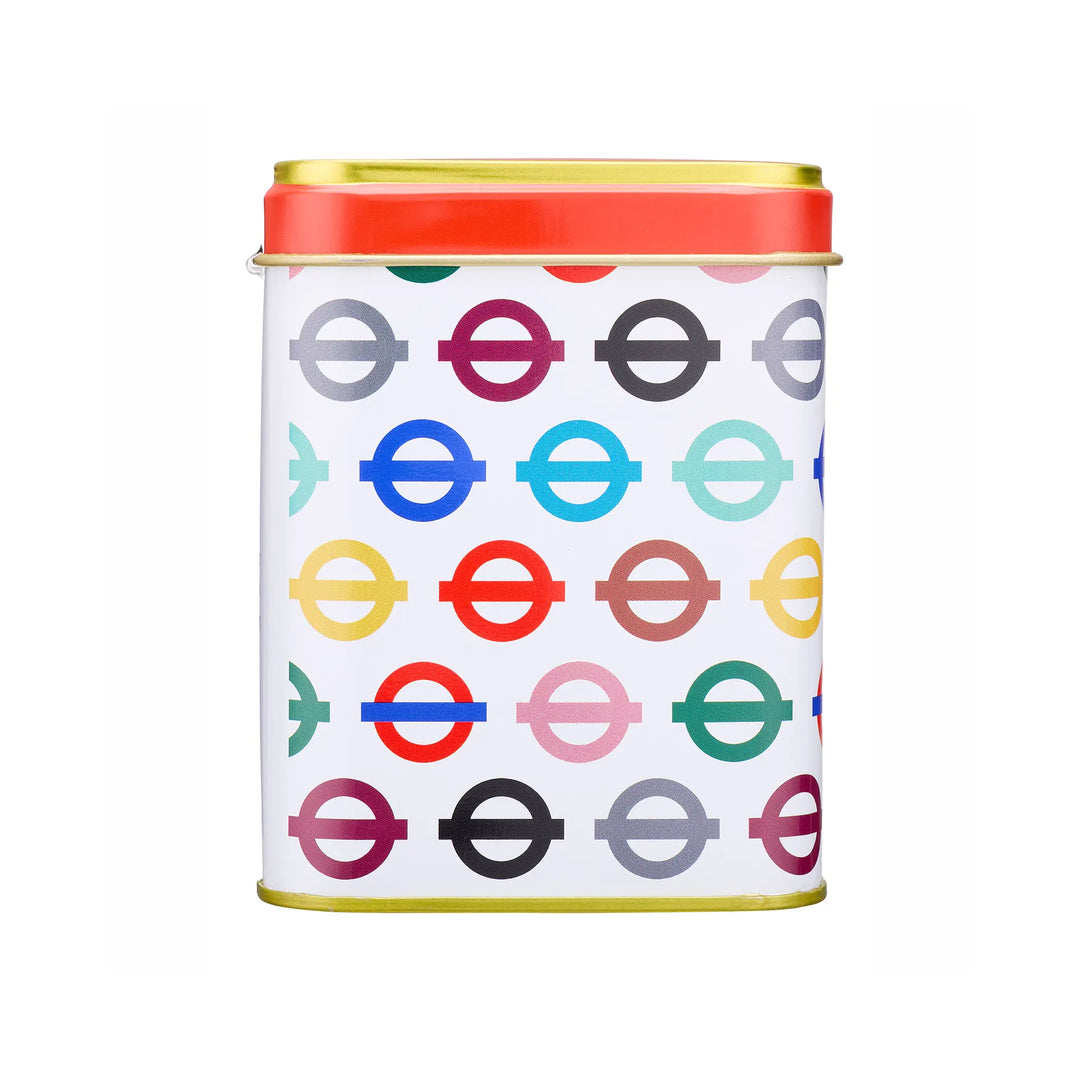 A square metal tin with a white body covered in a repeating pattern of colorful London Underground roundel logos, topped with a red lid and gold rim, on a plain white background.