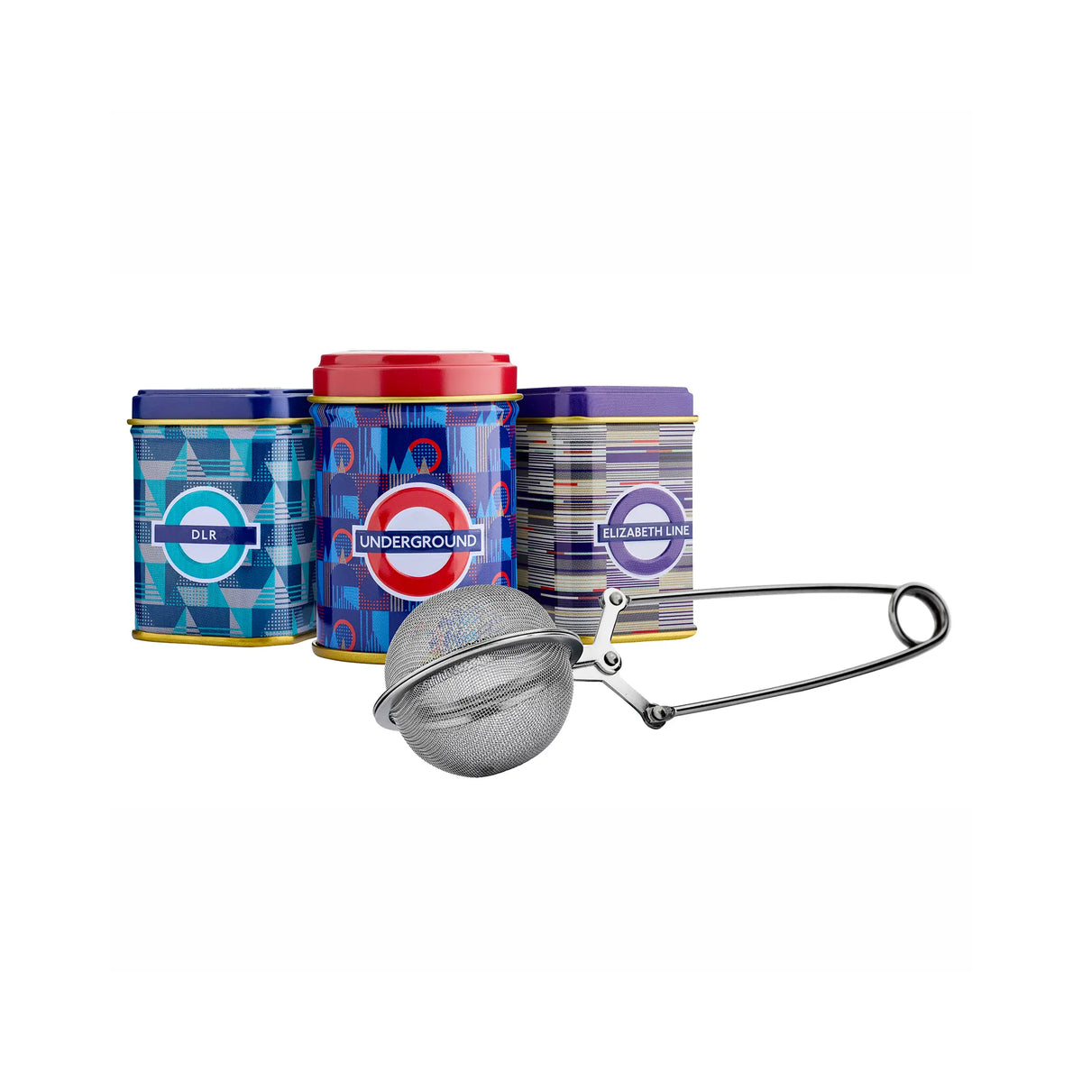 Three London Underground-themed metal tea tins in blue, red, and purple designs, shown with a stainless steel mesh tea infuser on a white background.