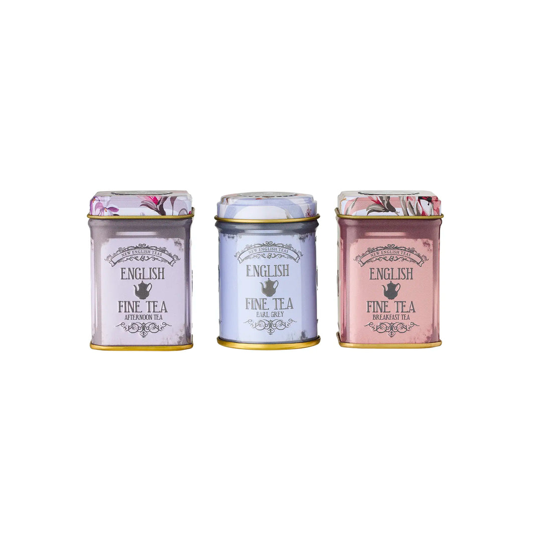 Three small tea tins with decorative labels on a white background